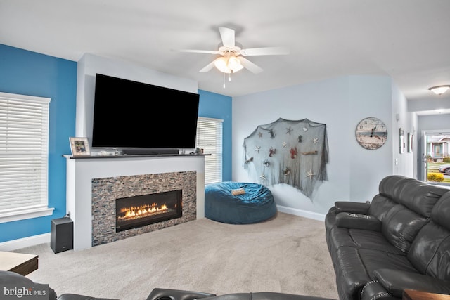 living room featuring carpet flooring, ceiling fan, and a fireplace