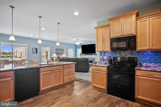 kitchen with decorative backsplash, sink, black appliances, pendant lighting, and dark hardwood / wood-style floors