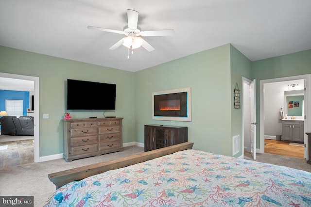 carpeted bedroom featuring ceiling fan and connected bathroom