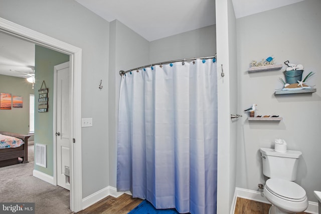 bathroom featuring ceiling fan, a shower with shower curtain, and toilet