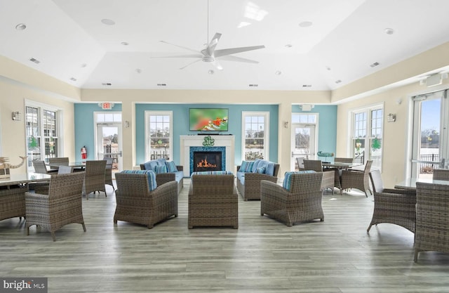 living room featuring hardwood / wood-style flooring, ceiling fan, and vaulted ceiling