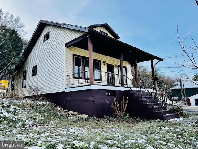 view of snowy exterior with covered porch