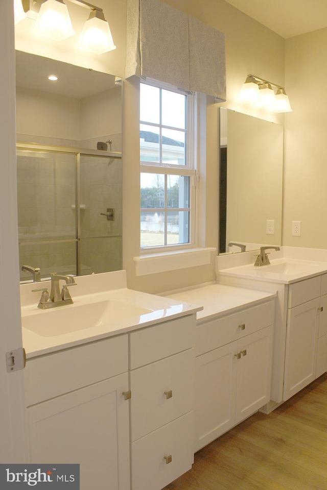 bathroom featuring a shower with door, wood-type flooring, and vanity