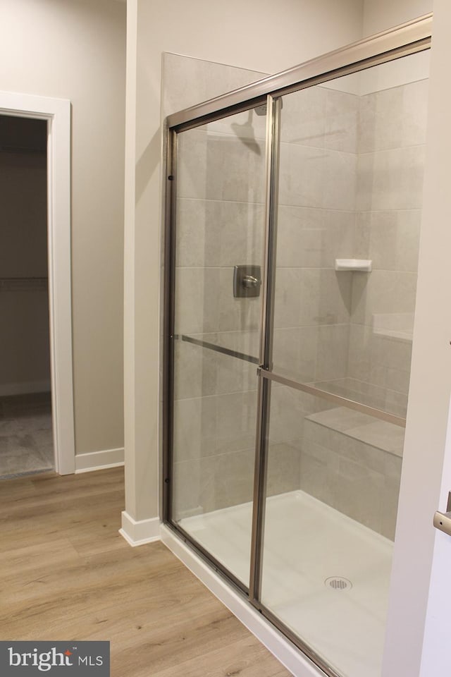 bathroom featuring wood-type flooring and a shower with door