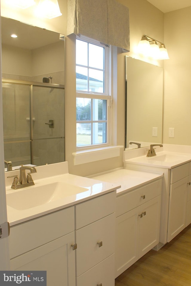 bathroom featuring hardwood / wood-style flooring, vanity, and an enclosed shower