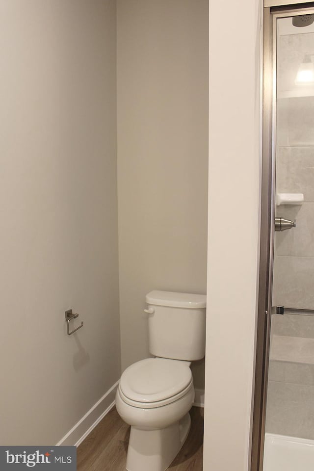 bathroom with toilet and hardwood / wood-style floors