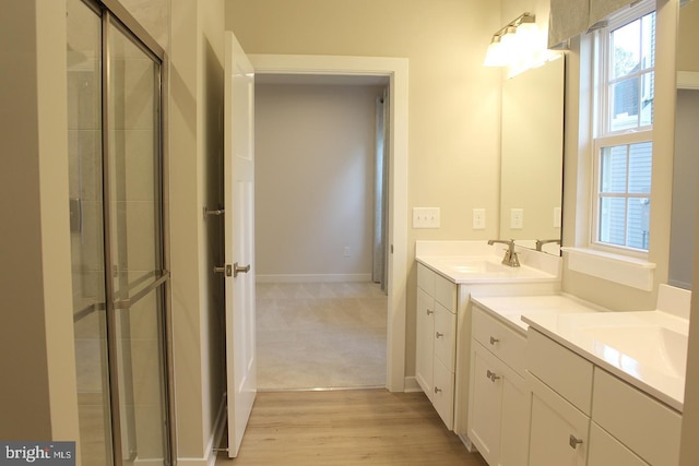 bathroom featuring hardwood / wood-style flooring, vanity, and a shower with door