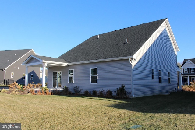 rear view of house featuring a yard