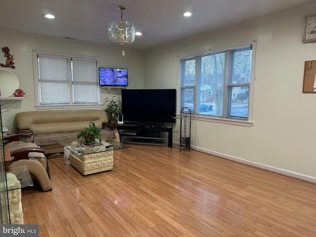 living room featuring a chandelier, light wood-type flooring, and ornamental molding