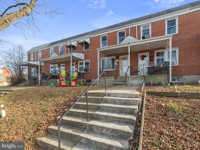 townhome / multi-family property with a porch and cooling unit