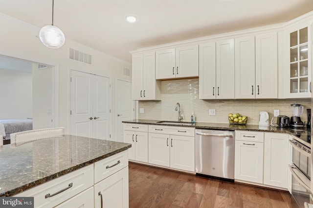 kitchen with pendant lighting, white cabinetry, stainless steel dishwasher, and sink