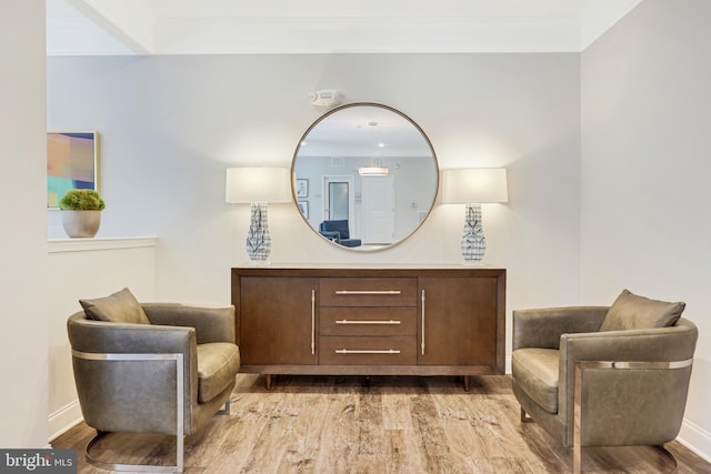 sitting room featuring light wood-type flooring and ornamental molding