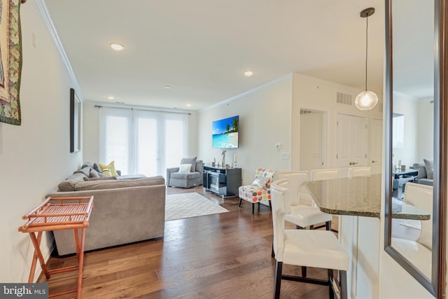 living room with wood-type flooring and crown molding