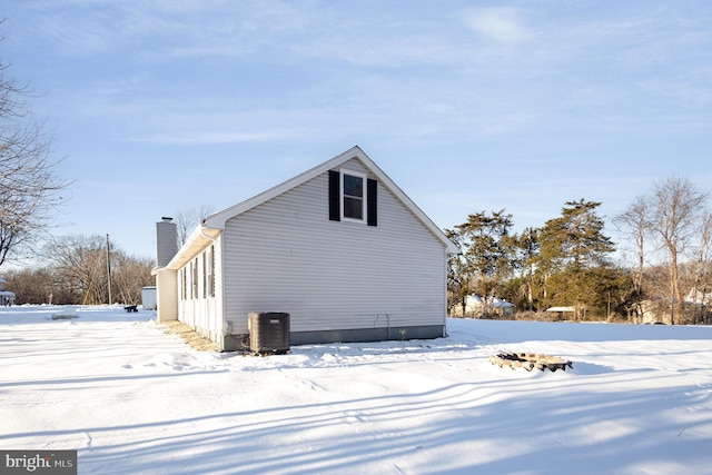 snow covered property with central AC unit