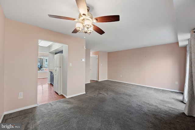 unfurnished living room featuring dark carpet and ceiling fan