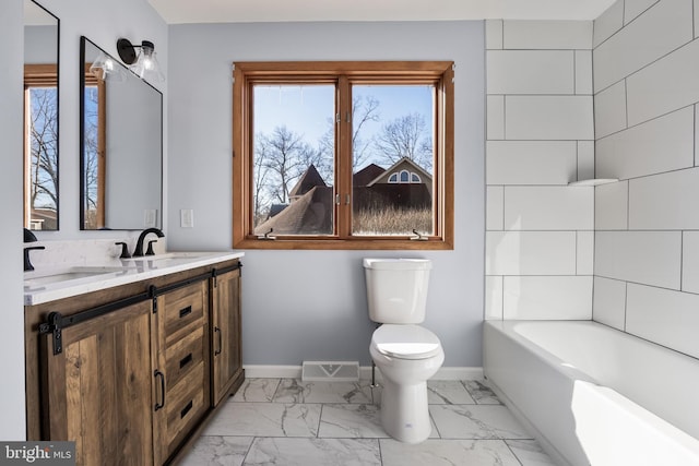 bathroom featuring toilet, vanity, and a tub to relax in