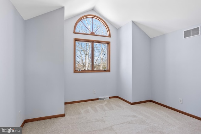 carpeted spare room with lofted ceiling