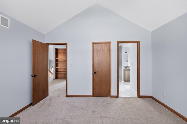 unfurnished bedroom with high vaulted ceiling and light colored carpet