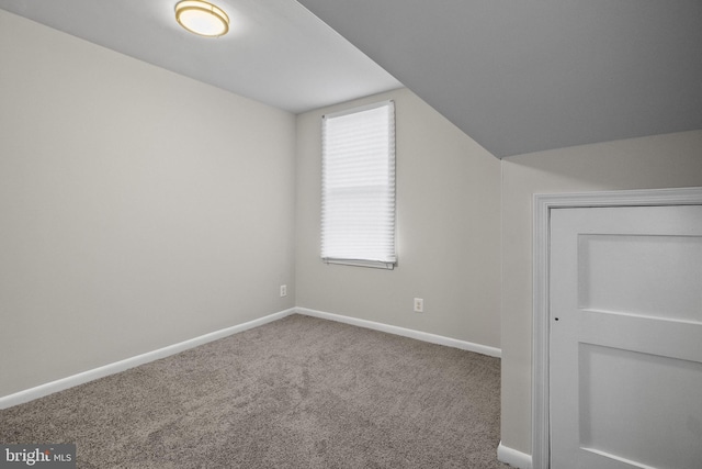 additional living space featuring carpet flooring and vaulted ceiling