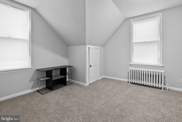 additional living space with carpet flooring, radiator, and lofted ceiling