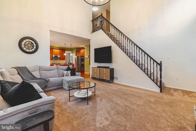 carpeted living room featuring a towering ceiling