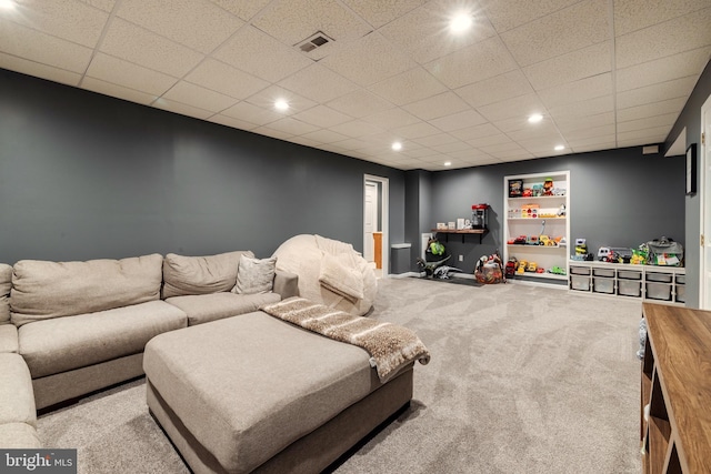 living room featuring carpet flooring and a drop ceiling