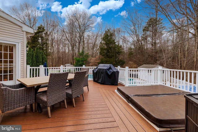 wooden deck with a grill and a covered hot tub