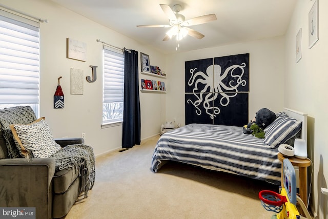 bedroom featuring multiple windows, light colored carpet, and ceiling fan