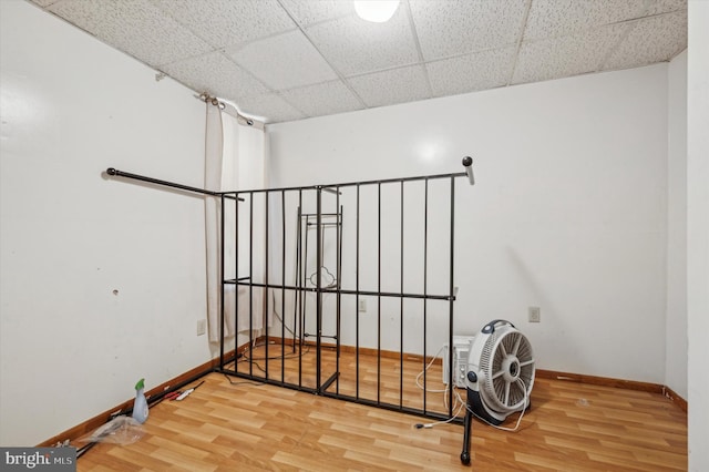 interior space featuring a drop ceiling and wood-type flooring