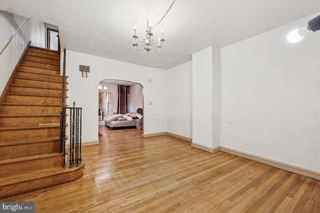 unfurnished room with hardwood / wood-style floors and a notable chandelier