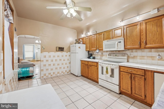 kitchen featuring light tile patterned floors, white appliances, tile countertops, and ceiling fan