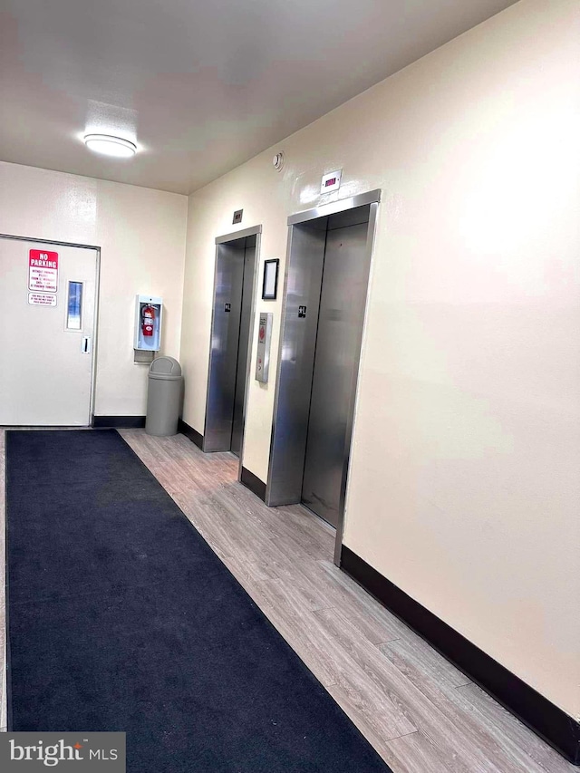 interior space featuring elevator and light hardwood / wood-style floors