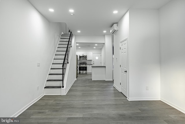 hallway with hardwood / wood-style flooring and a wall unit AC