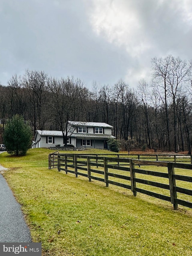 view of front facade with a front lawn and a rural view