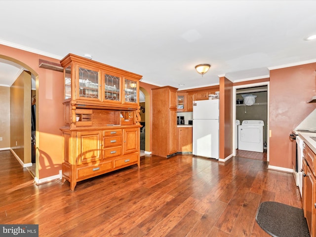 kitchen with dark wood-type flooring, white refrigerator, range with electric cooktop, ornamental molding, and washing machine and clothes dryer