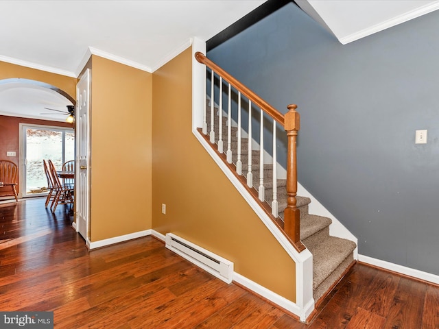 stairs with a baseboard radiator, hardwood / wood-style flooring, and crown molding