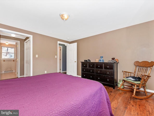 bedroom featuring hardwood / wood-style flooring and a baseboard radiator