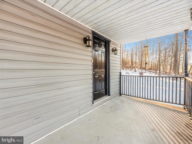 snow covered property entrance with covered porch