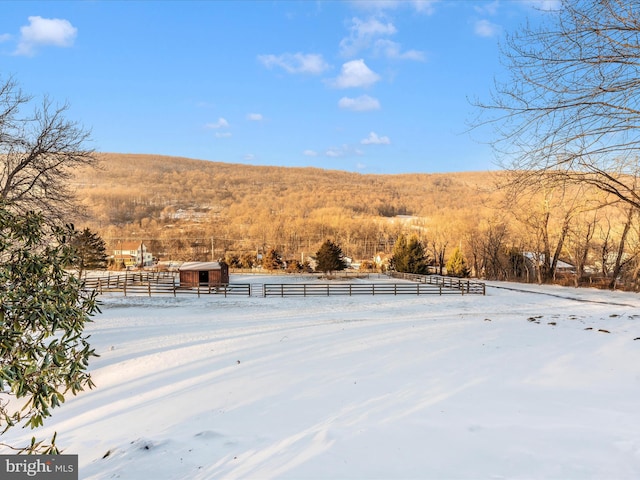 yard layered in snow featuring a rural view