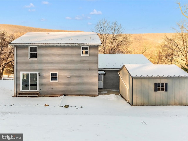 view of snow covered rear of property