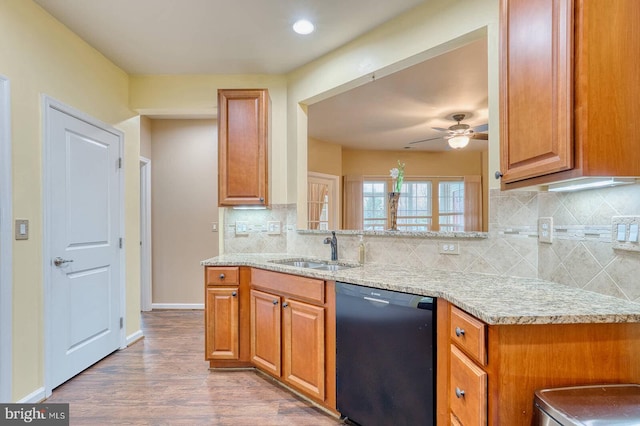 kitchen featuring ceiling fan, dishwasher, sink, kitchen peninsula, and light wood-type flooring