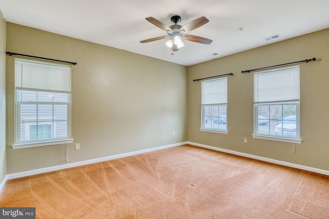 spare room featuring ceiling fan and light colored carpet