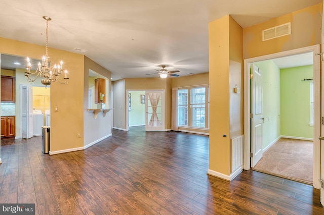 unfurnished living room with washer and clothes dryer, ceiling fan with notable chandelier, and dark hardwood / wood-style floors