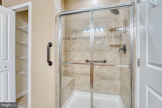 bathroom featuring tile patterned floors and a shower with shower door