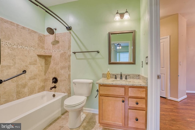 full bathroom featuring tiled shower / bath combo, toilet, and vanity