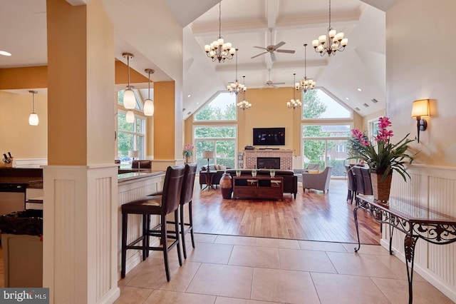 kitchen with a breakfast bar, light tile patterned flooring, a wealth of natural light, and ceiling fan