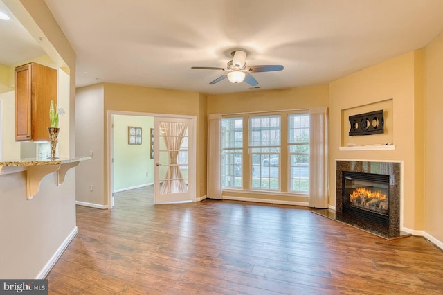 unfurnished living room with ceiling fan and dark wood-type flooring