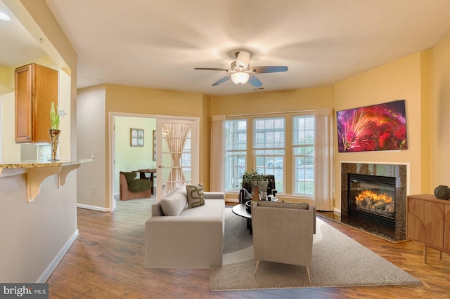 living room featuring ceiling fan and dark hardwood / wood-style flooring