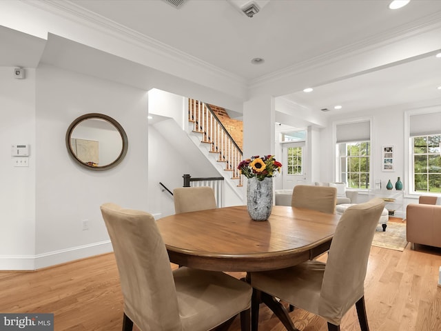 dining space featuring crown molding and light hardwood / wood-style flooring