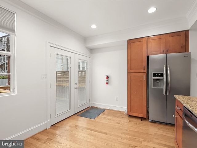 kitchen with french doors, crown molding, light hardwood / wood-style flooring, light stone counters, and stainless steel appliances